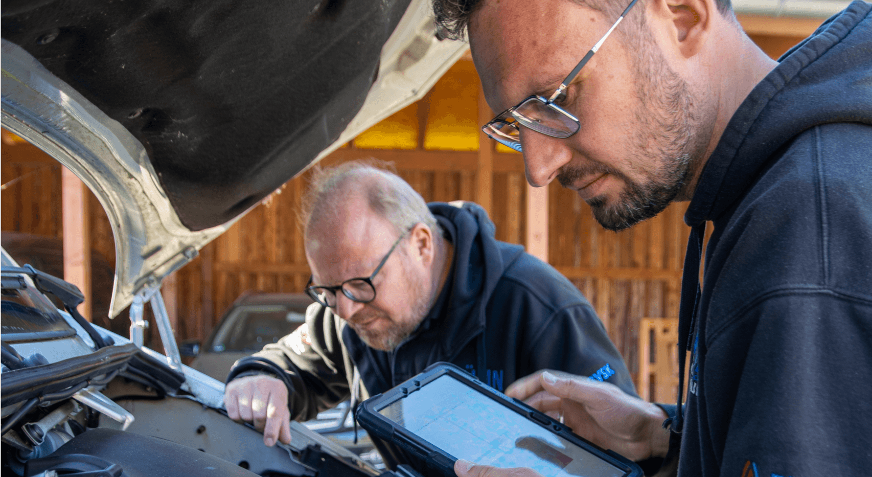  Die Kfz-Software CombiPlus Online wird auf einem Tablet verwendet, um Schadenfälle direkt vor Ort zu bearbeiten. Auf dem Bild ist zu sehen, wie ein Techniker mit einem Tablet das Fahrzeug untersucht, während er gleichzeitig Fahrzeugdaten in die Software eingibt. Diese Technologie hilft dabei, den Schadenfall schnell und effizient zu dokumentieren, ohne dass zusätzliche Büroarbeit erforderlich ist. Die Software ermöglicht eine direkte Eingabe von Fahrzeuginformationen und Schadenbildern, was die Arbeitsabläufe im Bereich der Fahrzeugschadenbewertung optimiert.