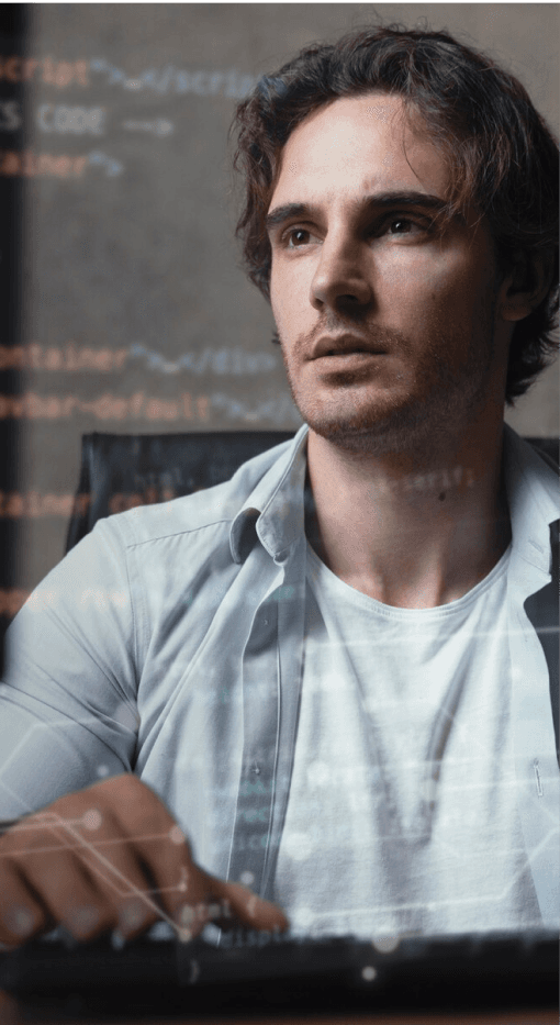 Das Bild zeigt einen jungen Mann, der vor einem Computer sitzt und intensiv auf den Bildschirm schaut. Im Hintergrund sind Codezeilen und digitale Daten sichtbar, die den Eindruck vermitteln, dass er an einem Programmierungs- oder Softwareprojekt arbeitet. Er trägt ein weißes T-Shirt unter einem offenen Hemd und scheint sich auf eine Aufgabe zu konzentrieren. Der Fokus auf den Code und die digitale Darstellung verstärken die technologische Atmosphäre der Szene. Es könnte eine Darstellung für Softwareentwicklung oder technisches Arbeiten sein.